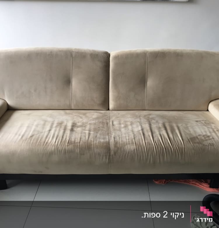 ספה עם כתמים, צינור שואב אבק ומטלית על הרצפה